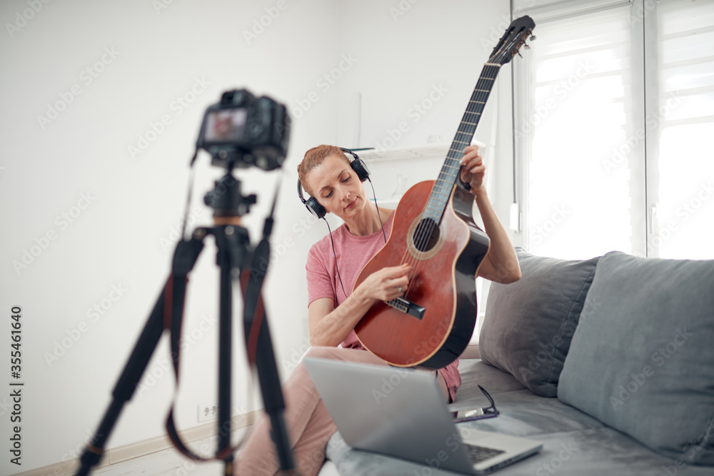 Fototapeta premium Guitarist making video lessons and tutorials for internet vlog website classes.