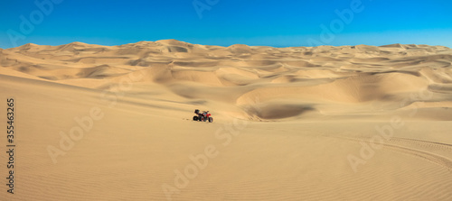 Quad driving in sand desert. ATV standing in middle of nowhere in sand dunes desert with skid marks. Africa  Namibia  Namib  near Walvis Bay  Swakopmund.