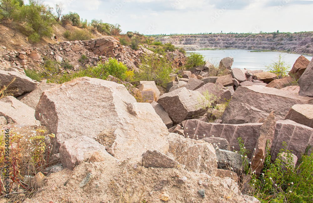 Old granite quarry with water. Large raw pieces of stone. Old granite quarry with water. Large raw pieces of stone.