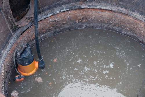 Foto close-up drain pump in a cesspool filled with contaminated water with feces