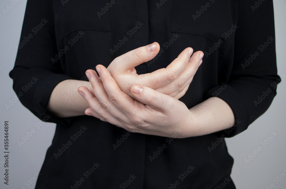 Obraz premium Woman suffers from pain in fingers. Arthritis or arthrosis, cartilage wear, rheumatism of the joints. Examination by a rheumatologist