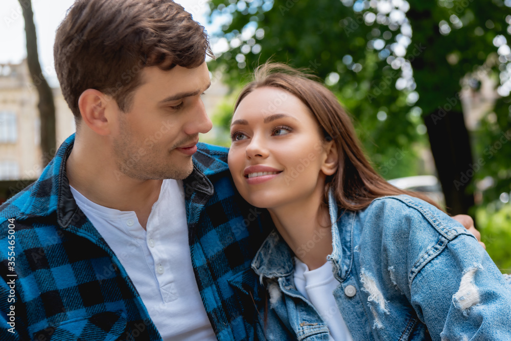 beautiful girl and handsome boyfriend smiling while looking at each other