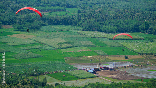 Paralayang terbang melayang di langit biru. photo