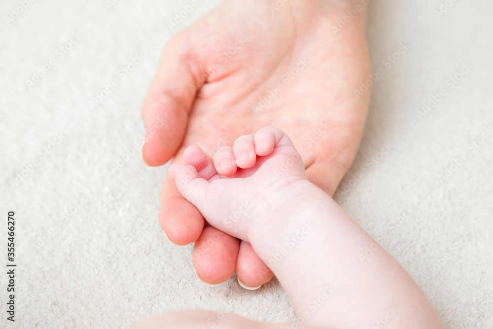 Baby hand on young mother palm. Closeup. Lovely, emotional, sentimental moment. Family concept. Baby hand on young mother palm. Closeup. Lovely, emotional, sentimental moment. Family concept.