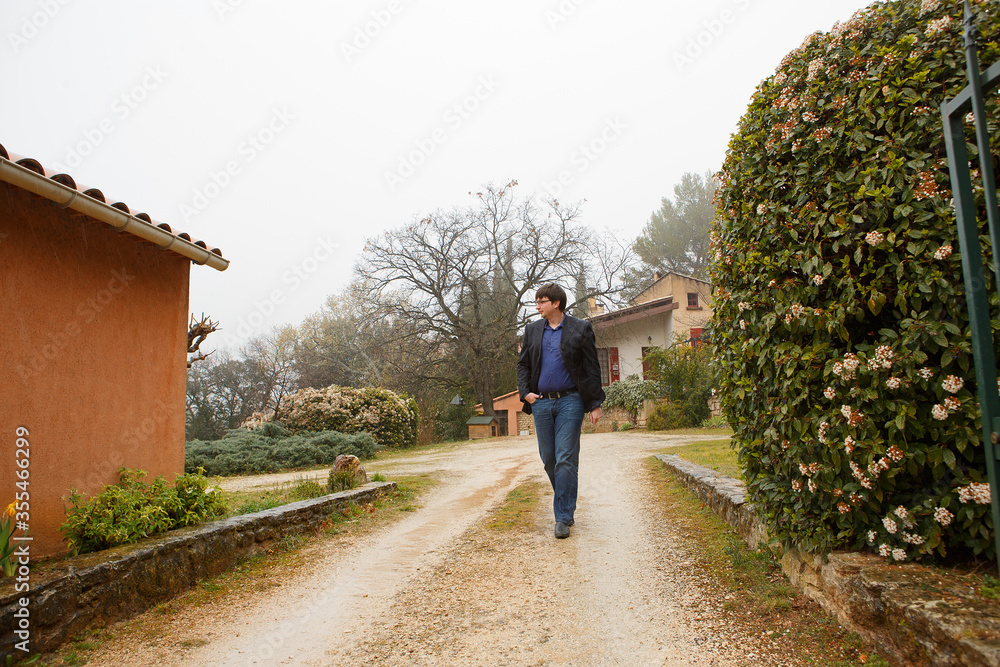 a man walks footpath in the village in the mountains in the spring. 