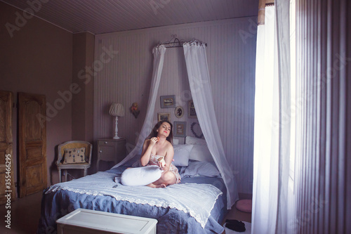 Provence. girl is powdering, wakes up in  morning in bedroom sun ray from window © andrey