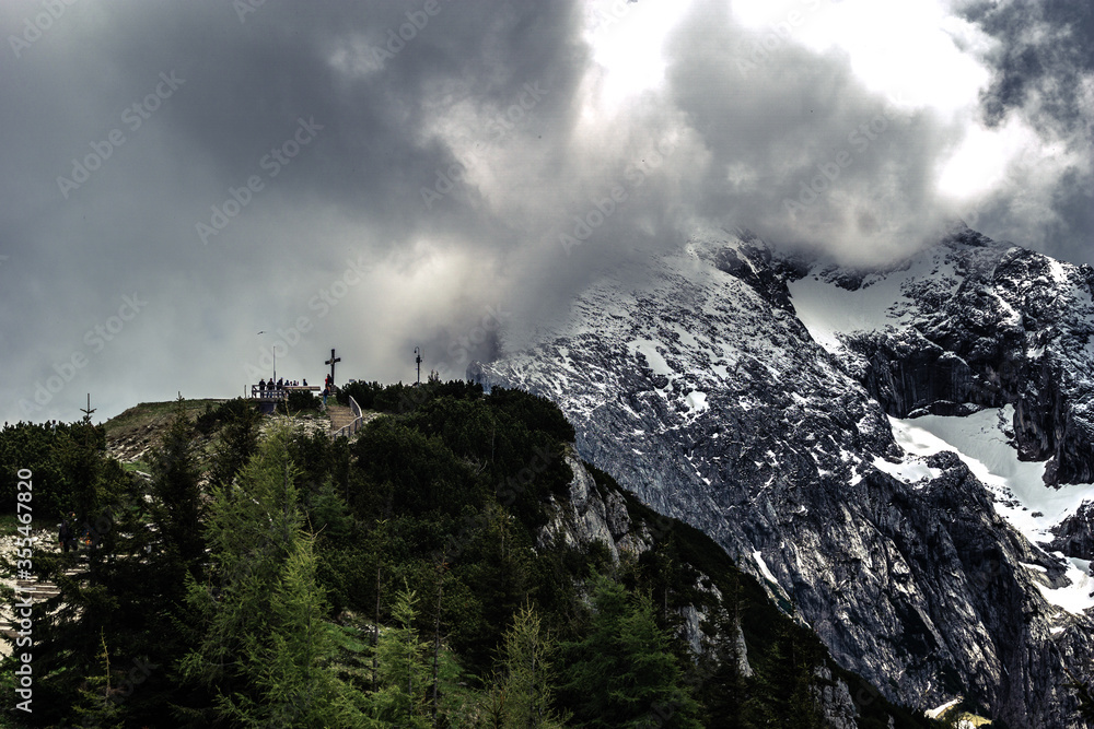 beautiful view of mountains in a panoramic area of bavaria in the alps near a chapel on a foggy cloudy day