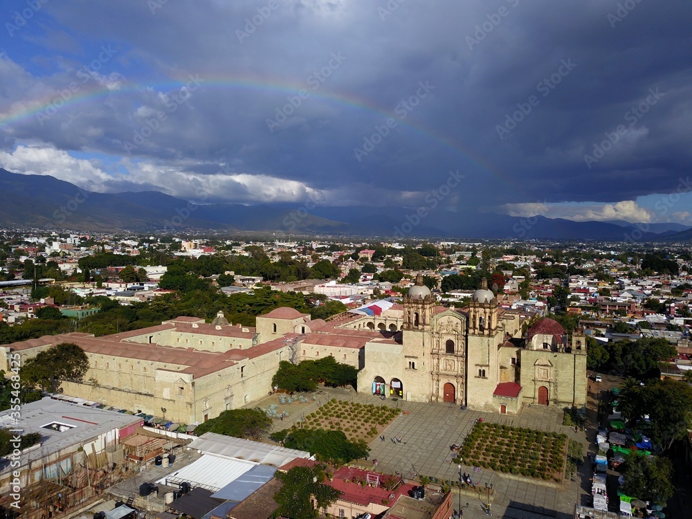 aerial view of Oaxaca with front view of Santo Domingo de Guzman church with thunderstorm clouds and rainbow