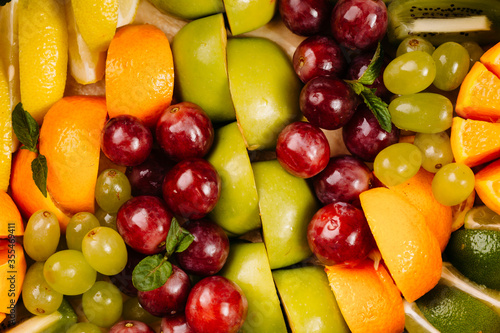 Collection of take away kraft boxes with different food. Set of containers with everyday fruits - grape apple kiwi orange jelly pineapple on white background  