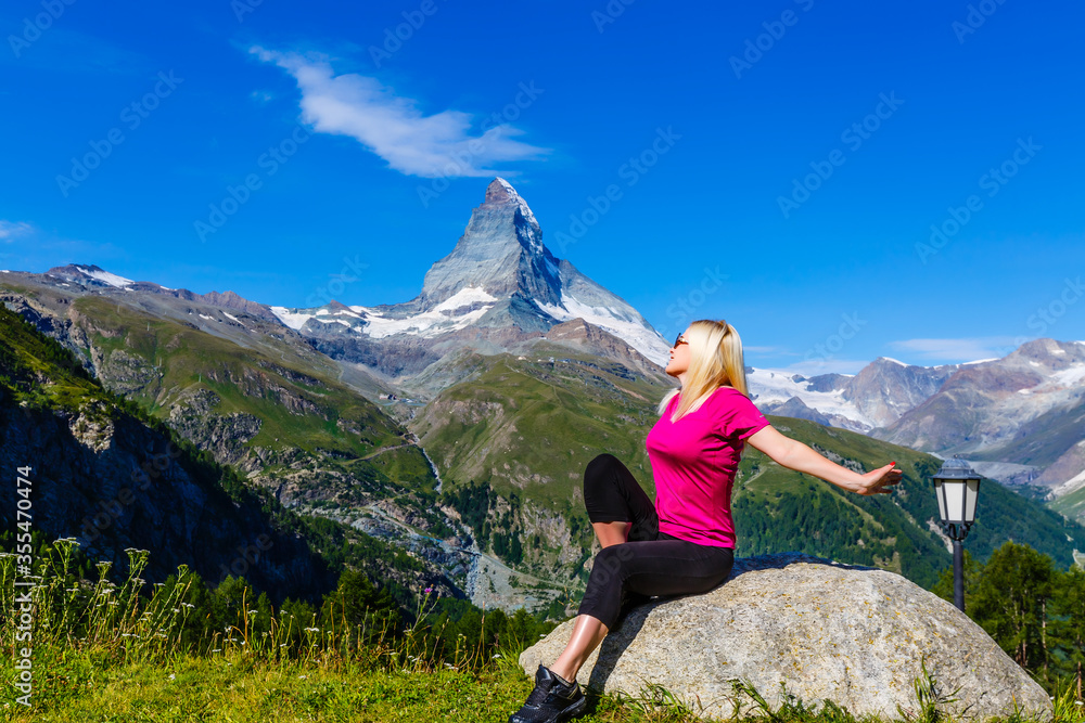 Little girl plays on the playground on the beautiful landscape background in the mountains