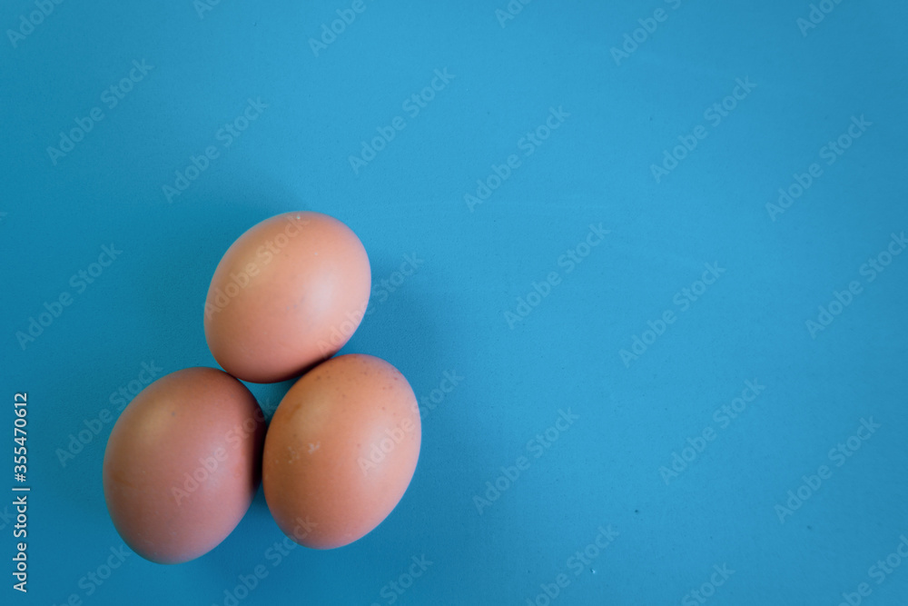 Three egg laying on a blue background Three egg laying on a blue background
