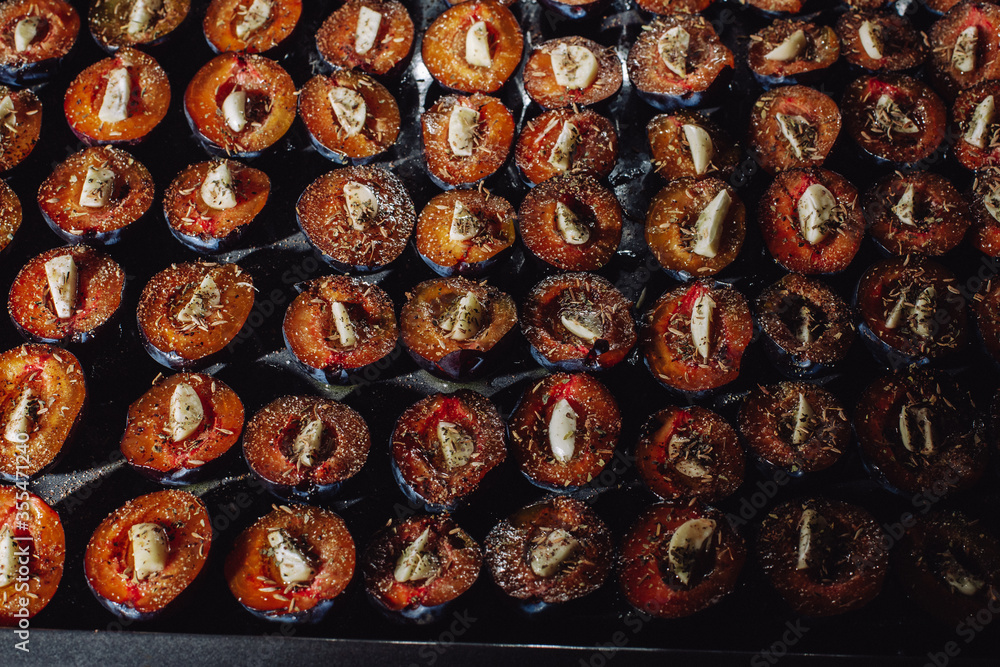 Prepare dried plums in the oven in the kitchen. Dried plums with garlic. Plums on a baking sheet. Plums and garlic in the oven. Prepare dried plums in the oven in the kitchen. Dried plums with garlic. Plums on a baking sheet. Plums and garlic in the oven.