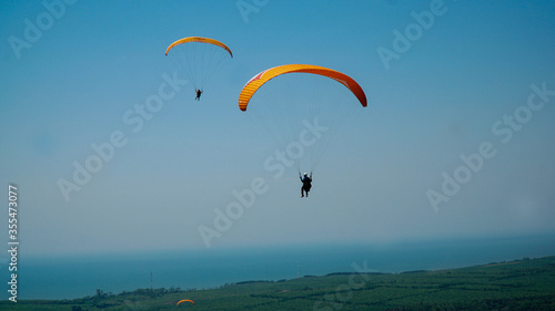 Paragliding flying in the blue sky.
