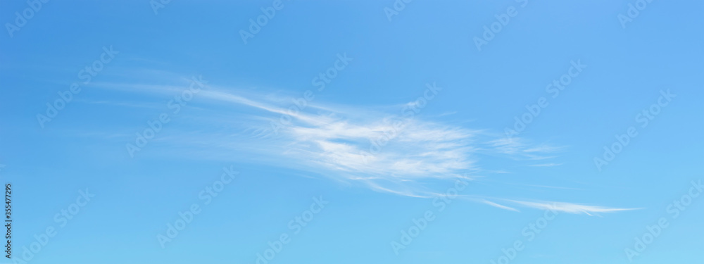 Panorama of light translucent cirrus cloud high in a clear blue summer sky. Meteorology, weather, cloud formation and atmospheric phenomena. Panorama of light translucent cirrus cloud high in a clear blue summer sky. Meteorology, weather, cloud formation and atmospheric phenomena.
