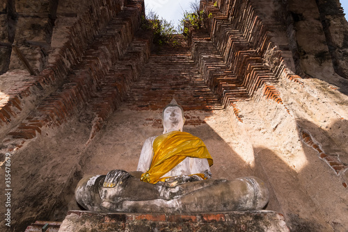 Old buddha statue with old wall brick of Wat Nakhon Luang Tample,Prasat Nakhon Luang in Ayutthaya,Thailand.