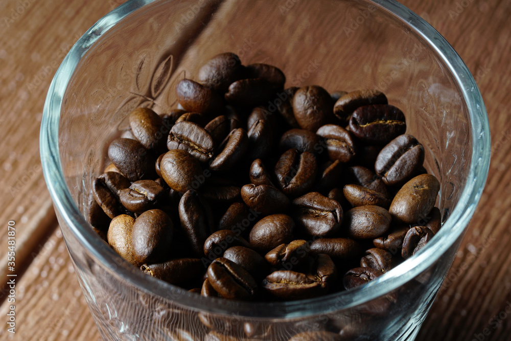 Fototapeta premium white cup and coffee beans scattered on wooden surface. food and beverage concept
