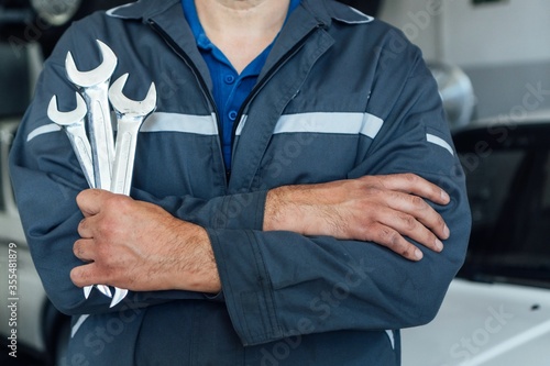 Mechanic s hands hold the work tools in the truck shop. Automatic car repair