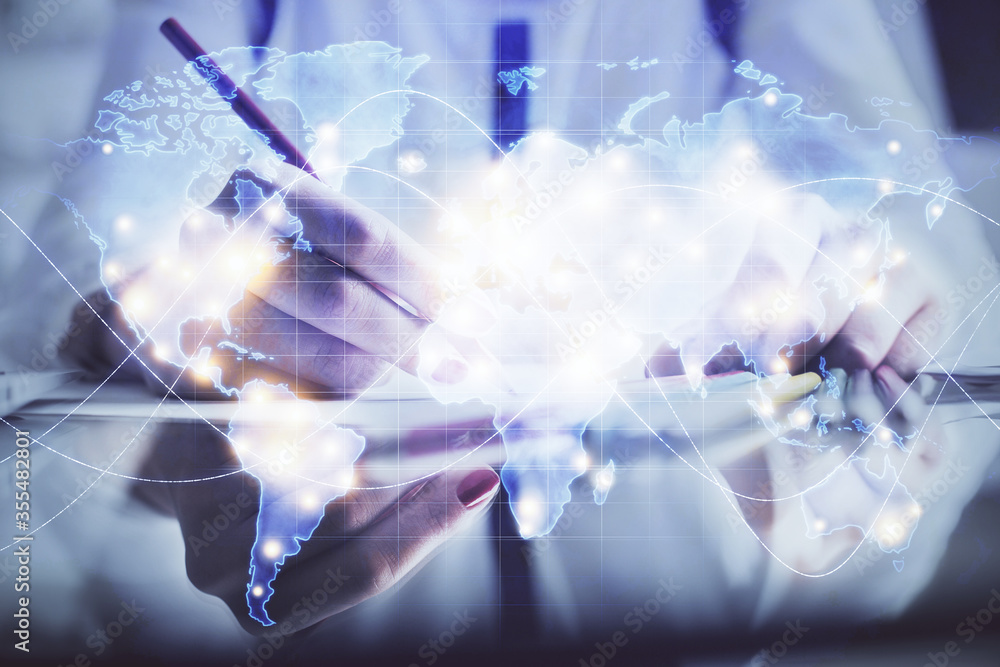 International business hologram over hands taking notes background. Concept of success. Multi exposure International business hologram over hands taking notes background. Concept of success. Multi exposure