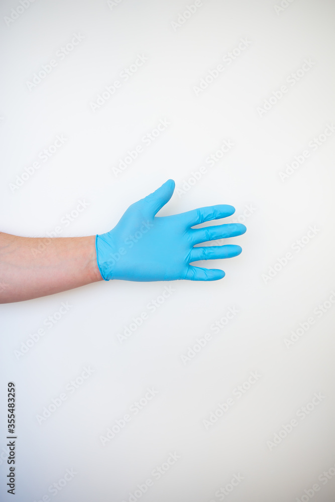 Hand in a blue medical disposable glove.