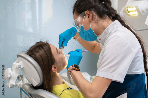 dentist treats teeth to a girl in a clinic