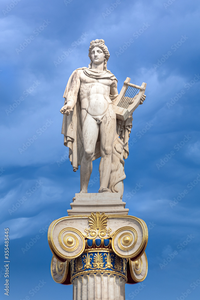Apollo statue with golden decorations against blue sky