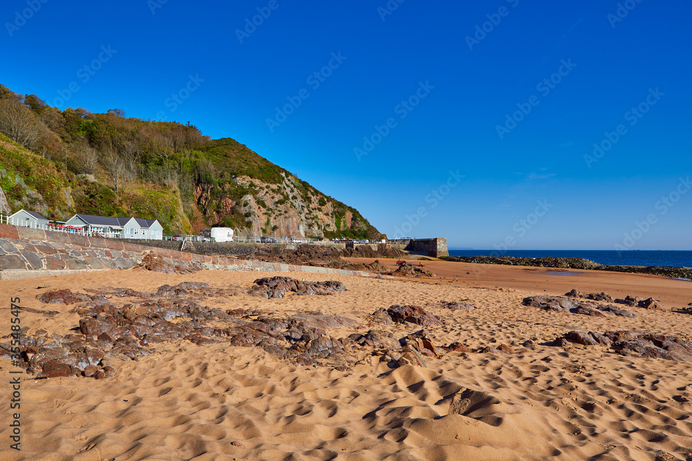 Image of La Greve de Lecq in the mornig sumer sunshine at low tide with sandy beach and clear blue sky. Jersey, Channel Islands, Uk