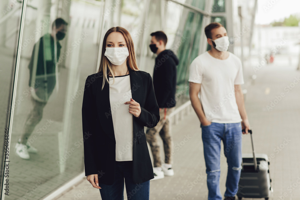 Figures of young people in protective masks near the airport. Safe travel during a pandemic. Airplane travel, quarantine and pandemic concept Figures of young people in protective masks near the airport. Safe travel during a pandemic. Airplane travel, quarantine and pandemic concept
