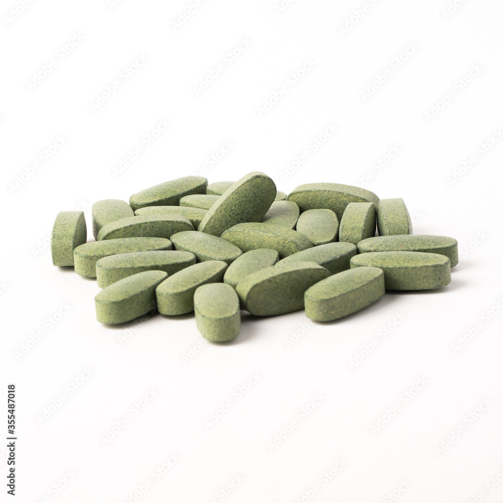 Green vitamin pills on a white background Green vitamin pills on a white background