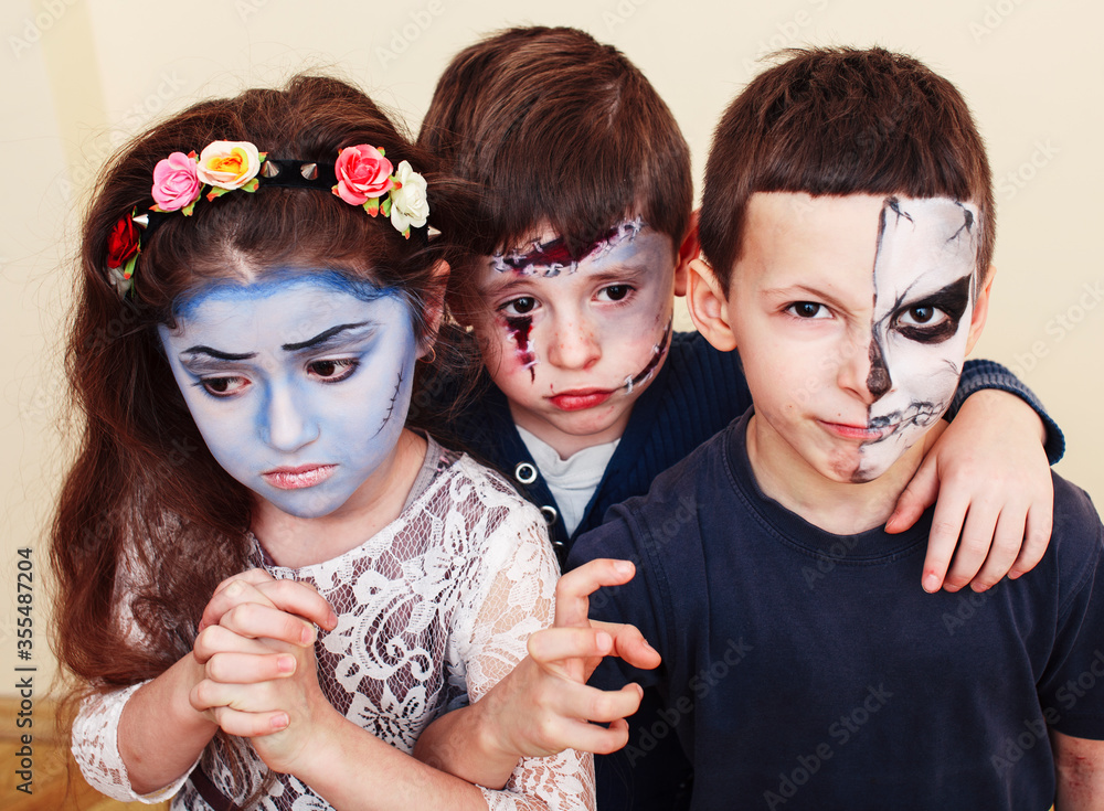 Obraz premium zombie apocalypse kids concept. Birthday party celebration facepaint on children dead bride, scar face, zombie skeleton together closeup makeup emotional posing.