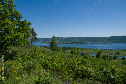 summer, day, rest, walk, observation, nature, distance, space, horizon, blue, sky, slopes, cliff, mountains, river, water, glare, ripples, overgrown, Bank, green, grass, vegetation, trees, shrub