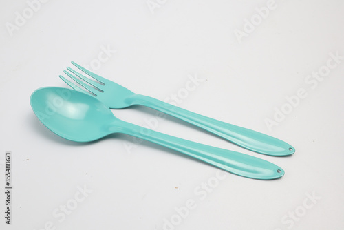 Green spoons and forks on a white background