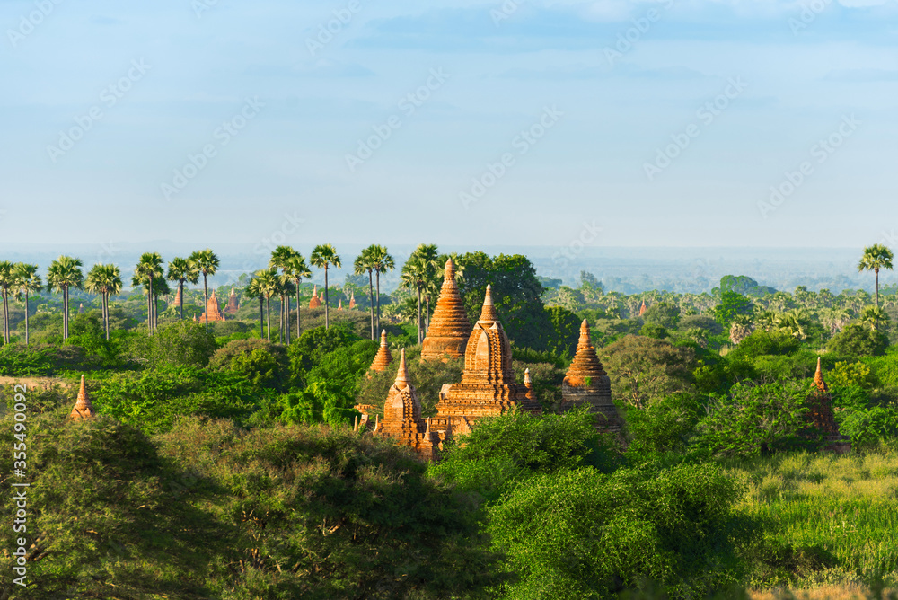 View of Ancient Pagodas in Bagan, Myanmar. Beautiful Morning Time with Blue Sky, Palm Trees 