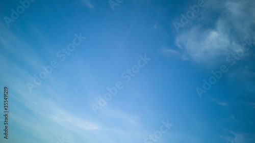 Light blue sky with white weightless clouds on beautiful sunny day. Backdrop, texture or banner in horizontal format.Abstract background for website,text,advertising,marketing or pattern. Copy space