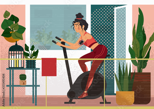 Work out on the veranda. A girl is cycling on exercise bike on the balcony on the fresh air. On the balcony we can see houseplants, a little table with a cage and candles