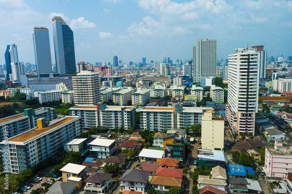 Naklejka premium View from the high floor of the streets of Bangkok. Tall buildings and roofs of small houses. City landscape