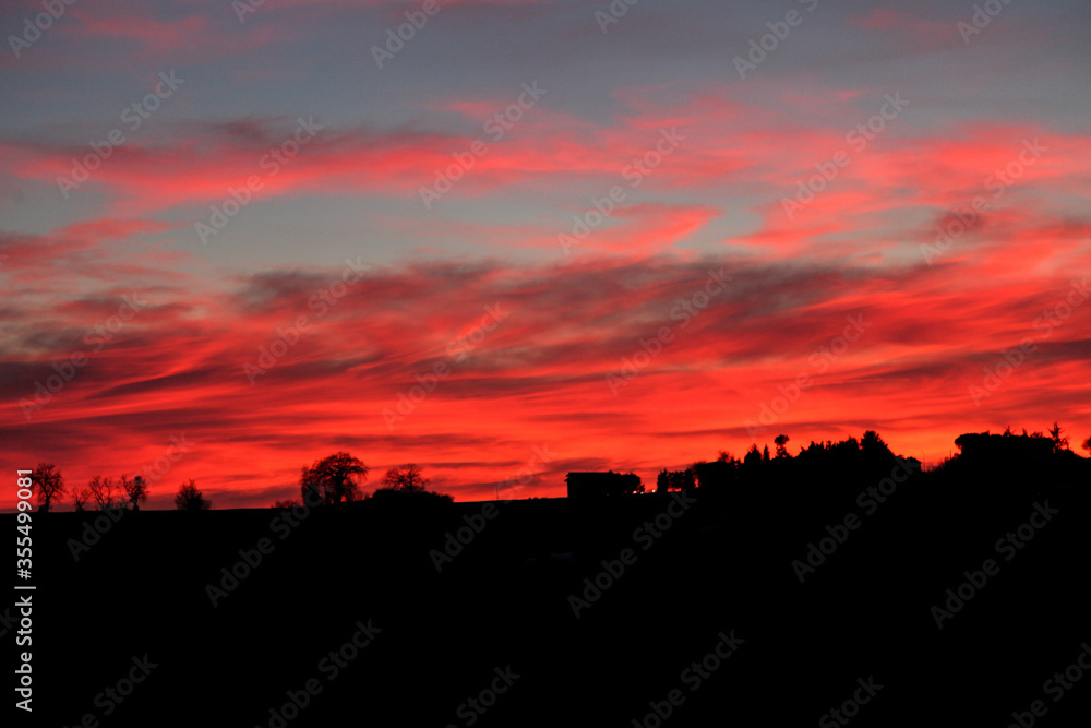 Fiery sunset with silhouette of houses