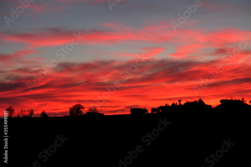 Fiery sunset with silhouette of houses