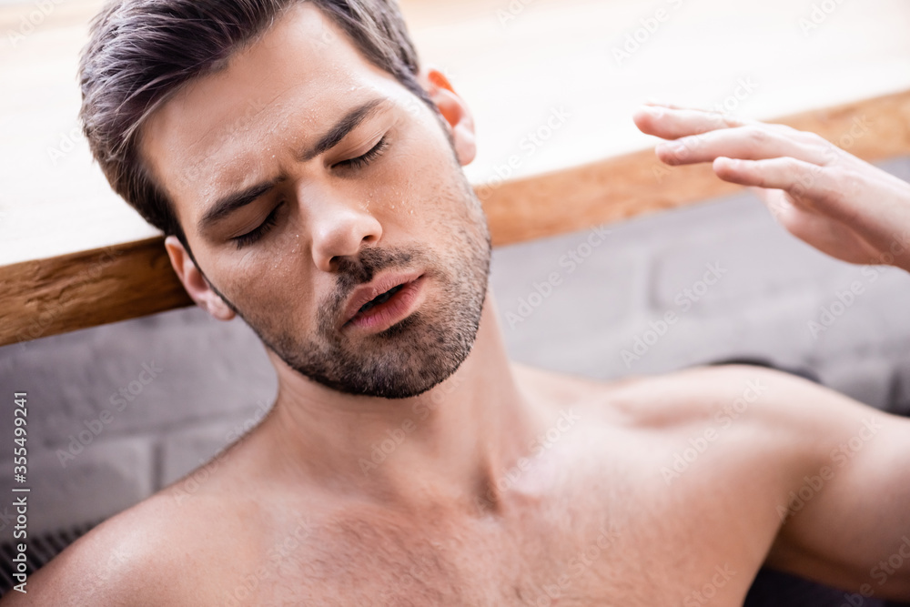 Obraz premium sexy man with closed eyes suffering from heat at home