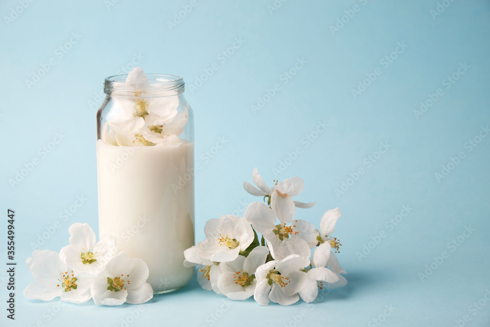 Milk of apple tree flowers on a blue background with copy space, the concept of natural cosmetics, aromatherapy, herbal medicine Milk of apple tree flowers on a blue background with copy space, the concept of natural cosmetics, aromatherapy, herbal medicine