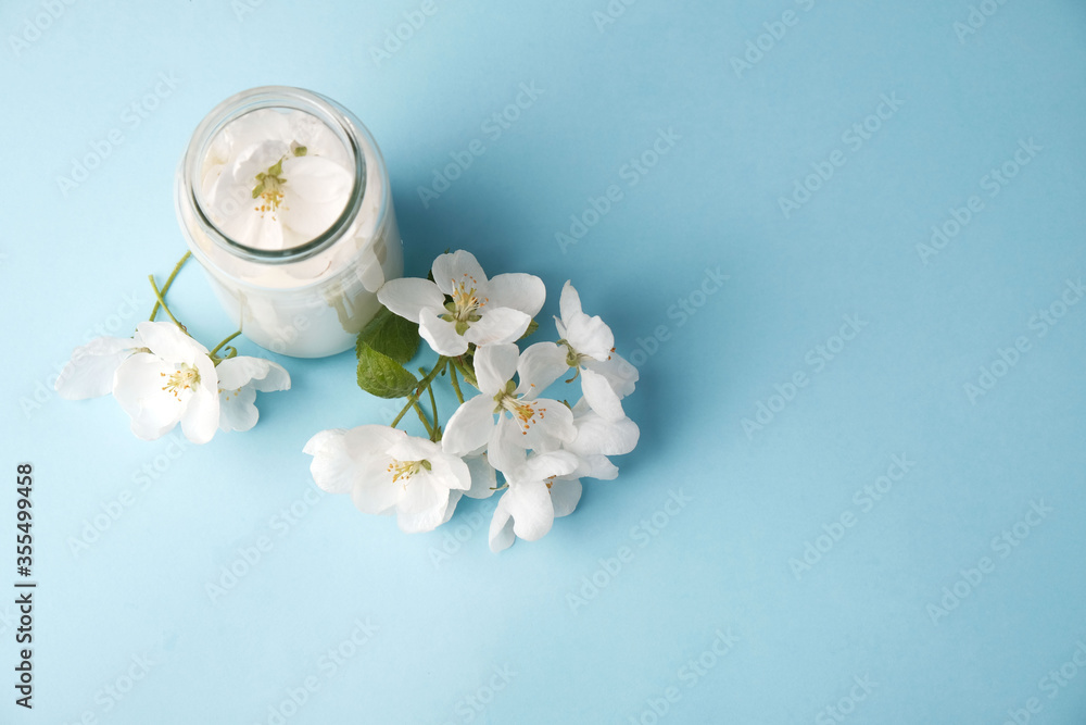 Milk of apple tree flowers on a blue background with copy space, the concept of natural cosmetics, aromatherapy Milk of apple tree flowers on a blue background with copy space, the concept of natural cosmetics, aromatherapy