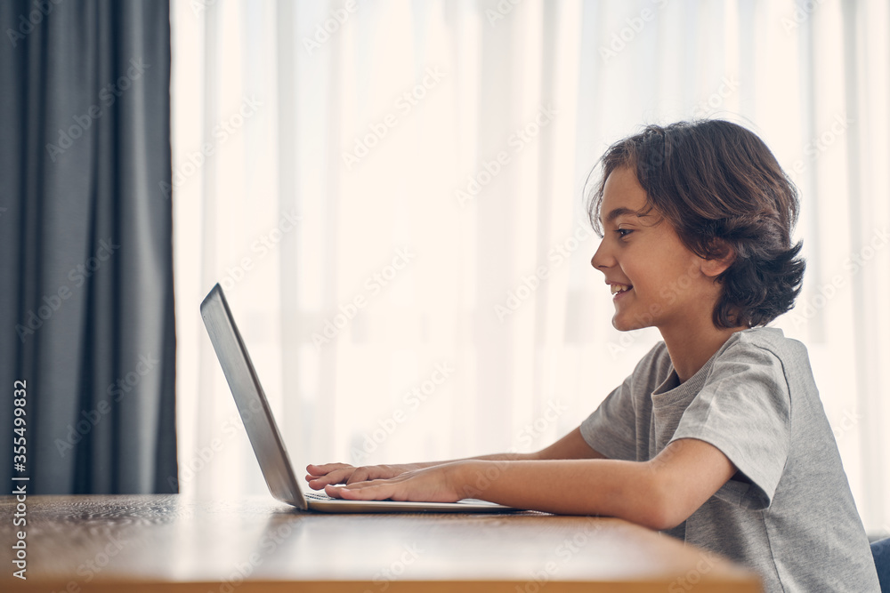 Smart little child using electronic device in room Smart little child using electronic device in room