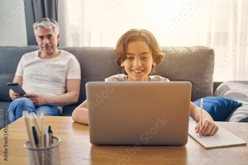 Father watching his son playing computer games