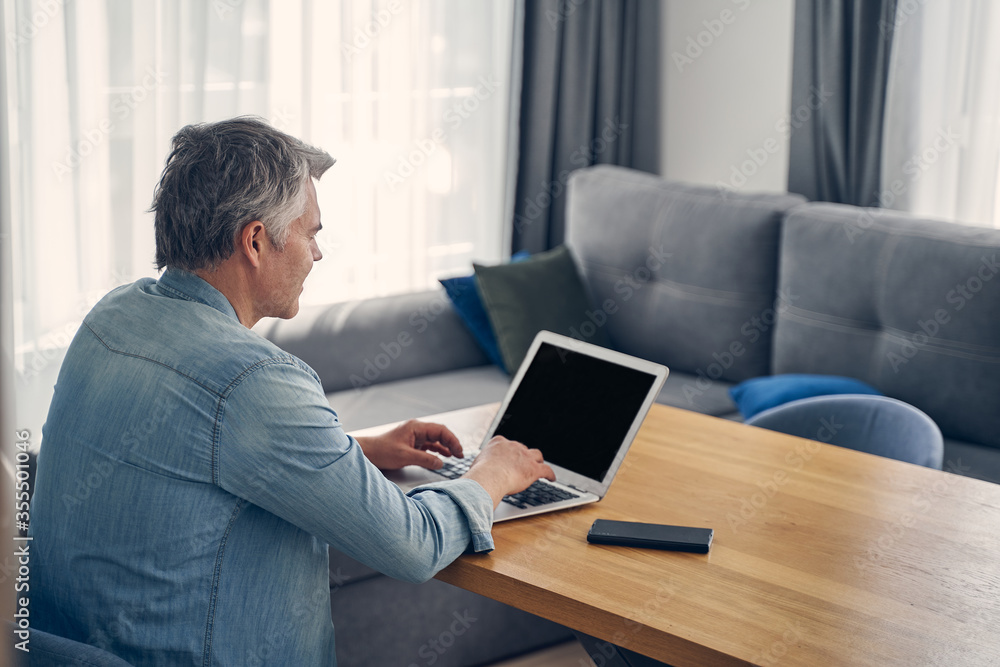 Grey-haired male staying at home with computer Grey-haired male staying at home with computer