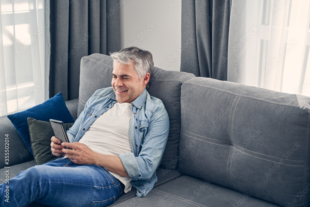 Smiling adult male enjoying time in cozy atmosphere Smiling adult male enjoying time in cozy atmosphere