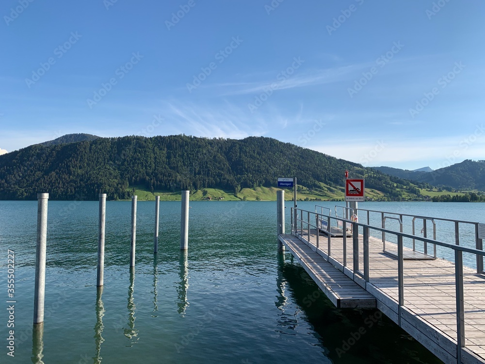 Schiffsteg - Steg, Bootsanlegestelle am Ägerisee - Aegerisee in Oberägeri mit Sicht auf Unterägeri, den Zugerberg und Berg Rigi / See in der Schweiz