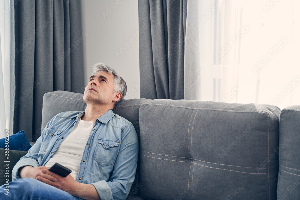 Man wearing jeans and shirt looking sad Man wearing jeans and shirt looking sad