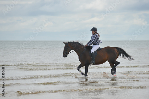 Every girls dream, riding a horse in the sea at the beach . A dream come true for this young woman as she and her horse enjoy the freedom to ride in the ocean.