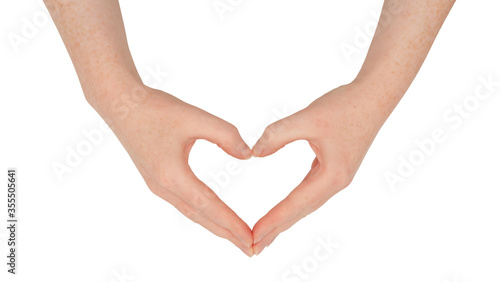 Freckled white hands  making a heart or love shape frame between thumb and index finger with fingers together.  Female hand isolated