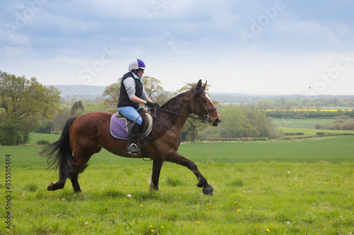 Horse and rider enjoy the togetherness and freedom of riding in the open countryside in rural Shropshire UK