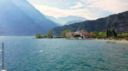 Aerial video with drone, view of the Torbole a small town on Lake Garda, Italy. Europa.beautiful Lake Garda surrounded by mountains in the summer time
